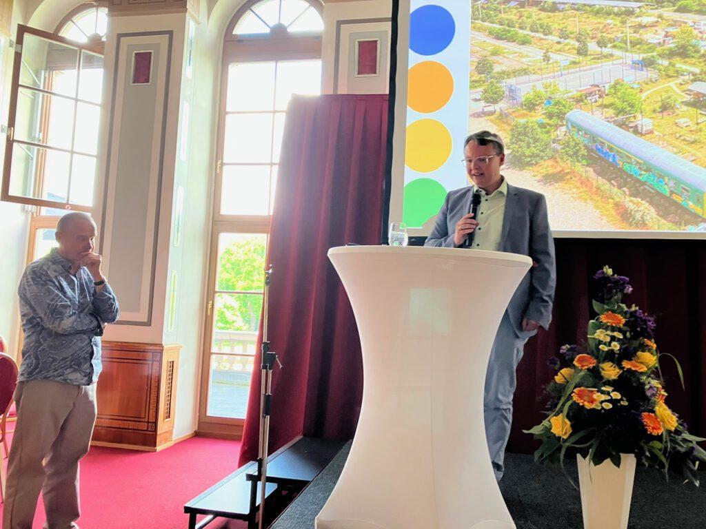 Vortragssituation im Ringcafé mit Blick auf Leinwand und Rednerpult