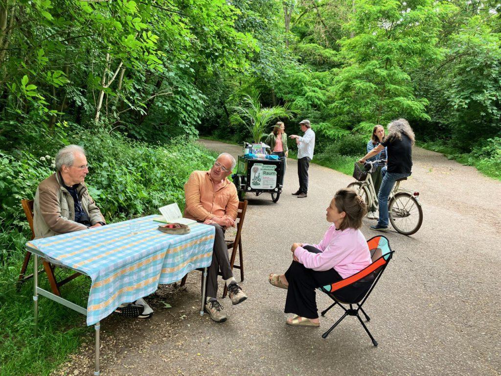 Gespräche am Tisch mit Lastenrad im Hintergrund