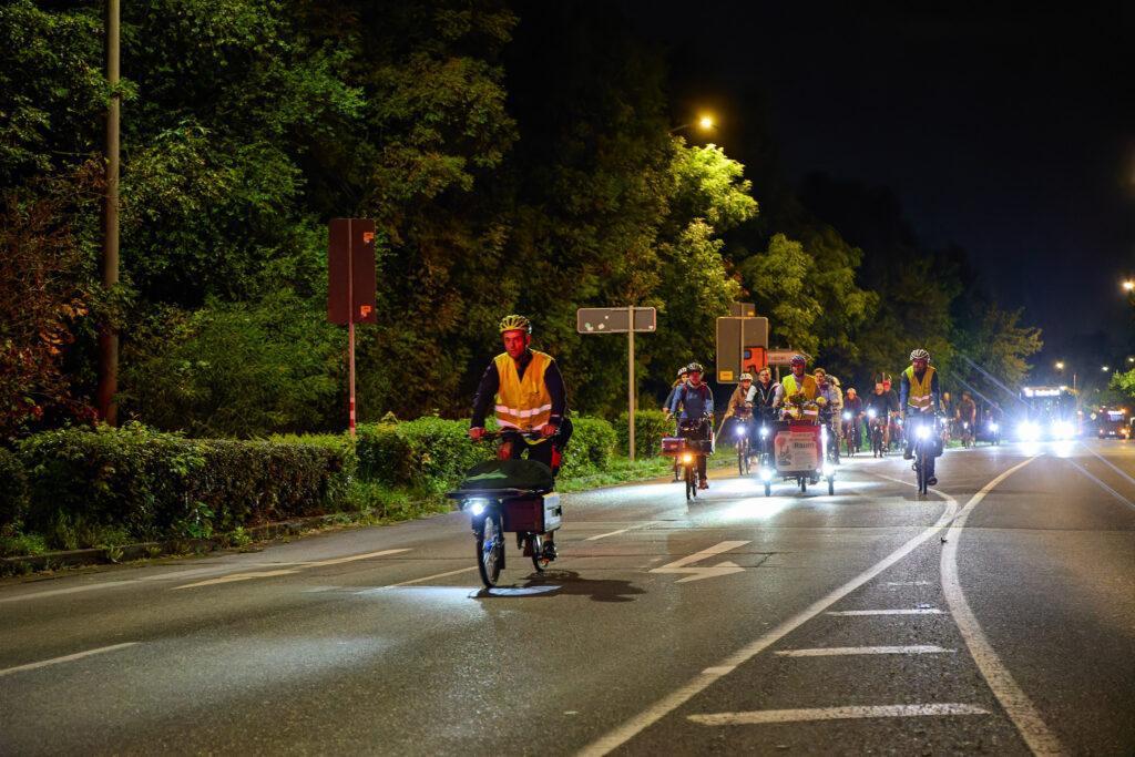 Radgruppe bei Nacht auf dem Weg zur nächsten Leinwand