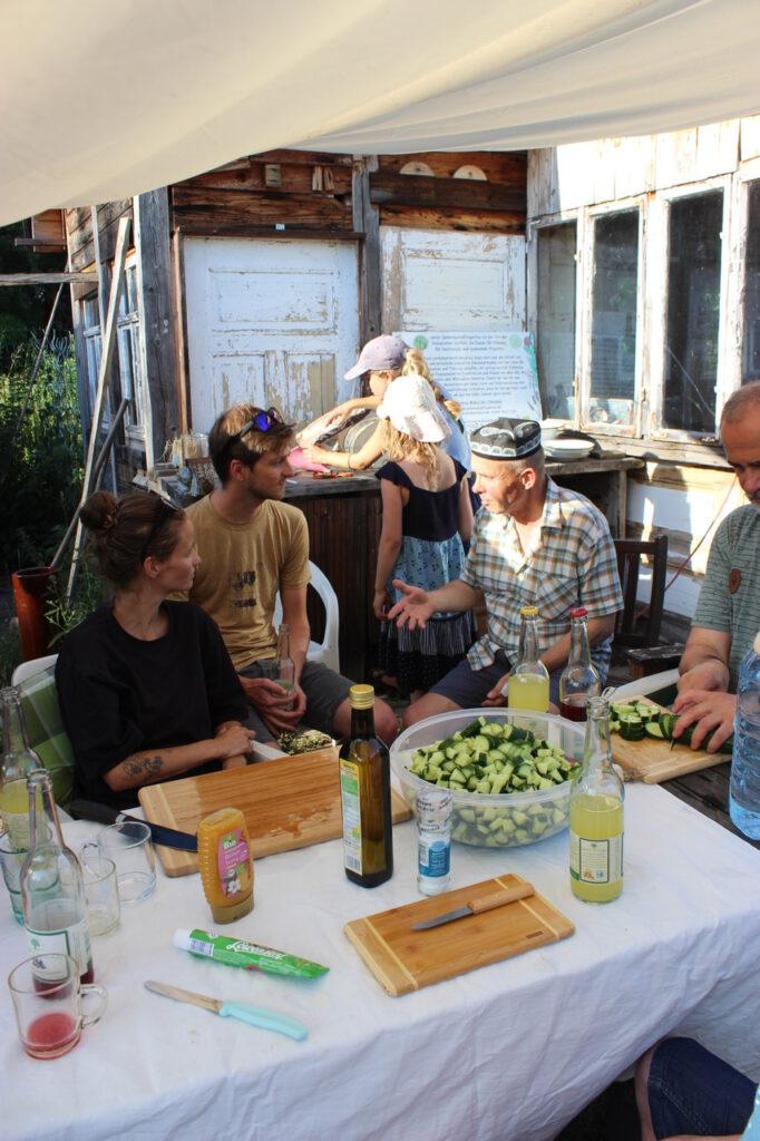 Gesprächsrunde beim gemeinsamen Kochen unter dem Pavillon