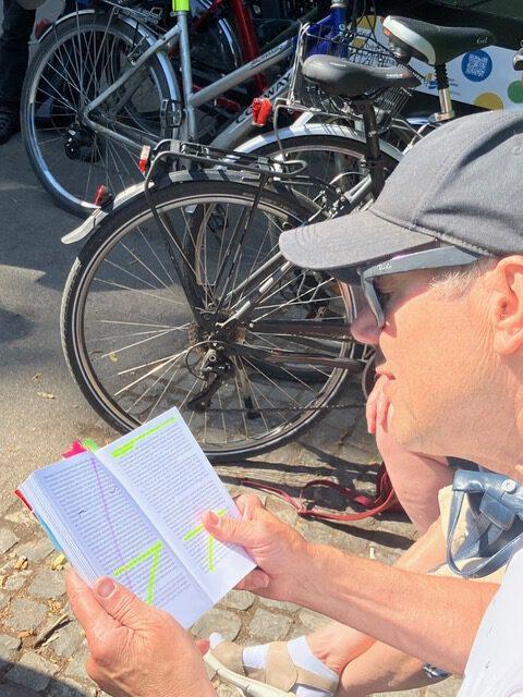 Teilnehmer liest das Buch Taxi nach Leipzig neben Fahrrädern